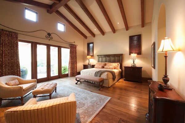 Spacious bedroom with high beams and ceiling