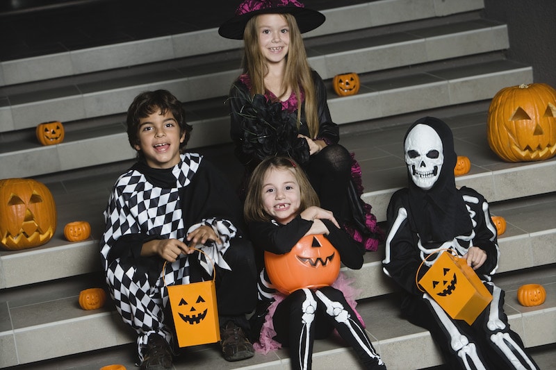 Portrait of boys and girls (7-9) wearing Halloween costumes on steps