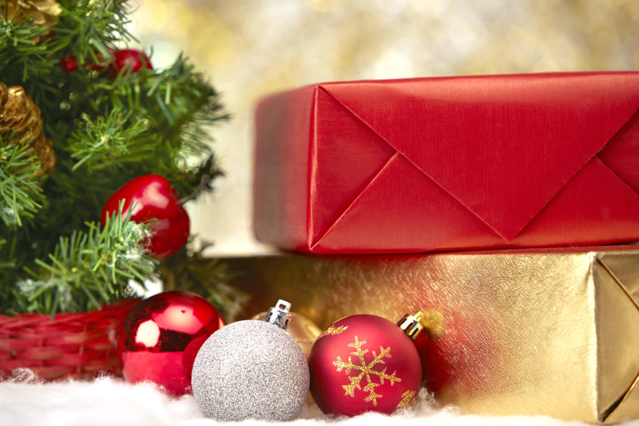 Gifts and decorations in front of small Christmas tree scaled